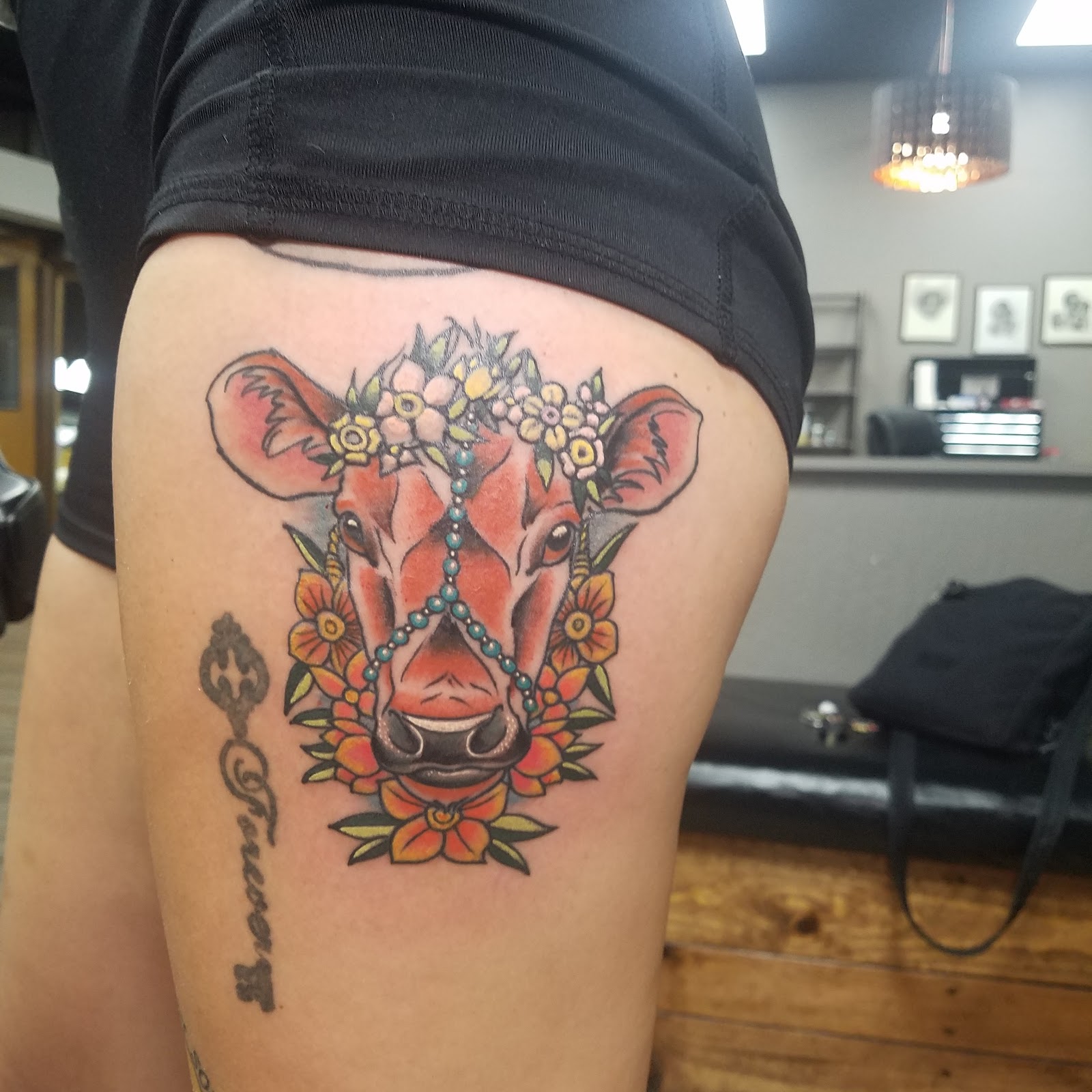 Color tattoo of a cow wearing a flower crown, photographed in the studio