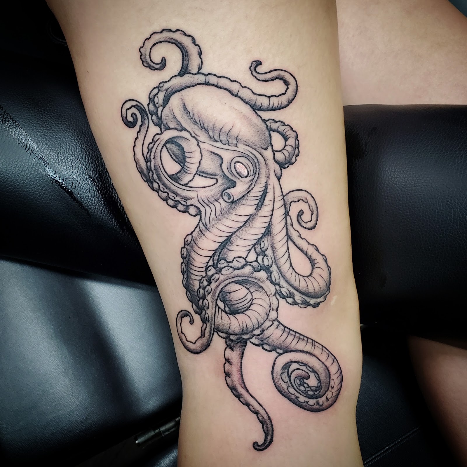 Black and gray octopus wrapping around a lower leg
